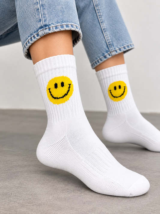 Smile Socken in Weiß mit gelbem Smiley, getragen zu Jeans und weißen Sneakern