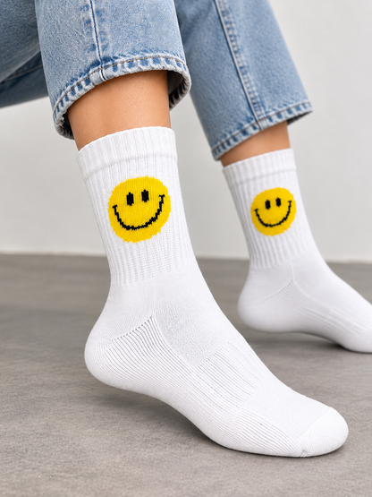 Smile Socken in Weiß mit gelbem Smiley, getragen zu Jeans und weißen Sneakern