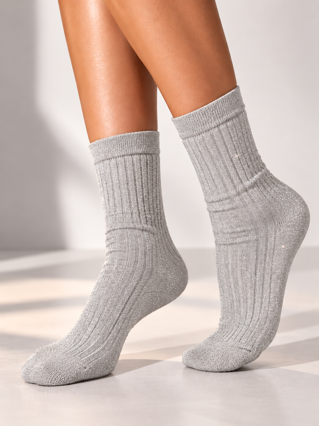 Glitzer Socken in Grau, an den Beinen getragen