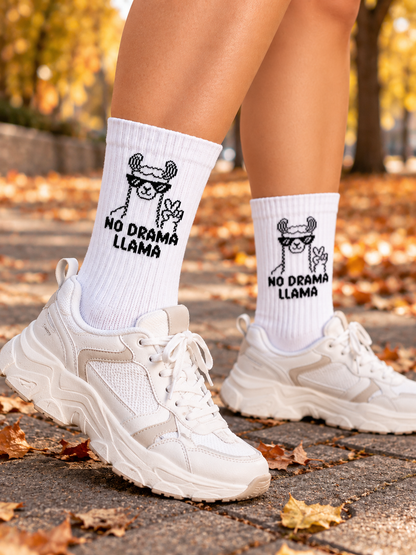 Llama Socken in Weiß, getragen zu hellen Sneakern im Herbstlaub