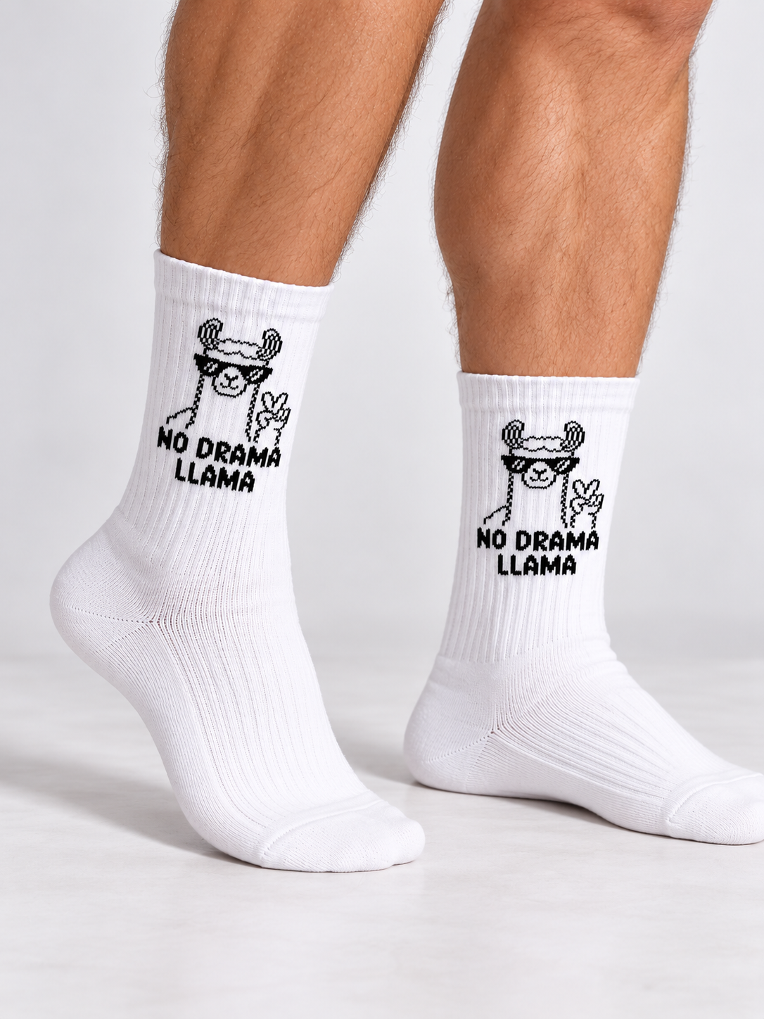 Llama Socken in Weiß mit schwarzem Lama-Motiv, an den Beinen getragen